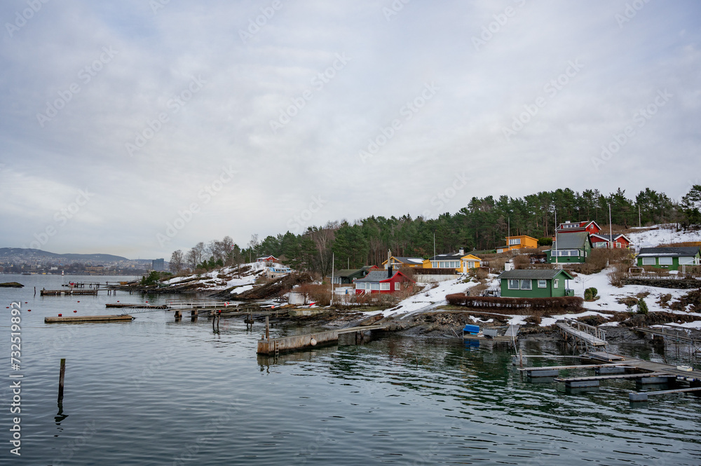 Traditional cottages on the islands around Oslo, in winter. Islands with houses. Norwegian colorful houses