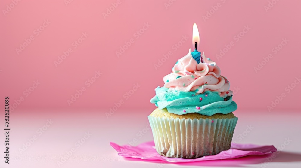 Colorful cupcake with a lit candle on a pink background. Colorful cupcake with a lit candle on a pink background.