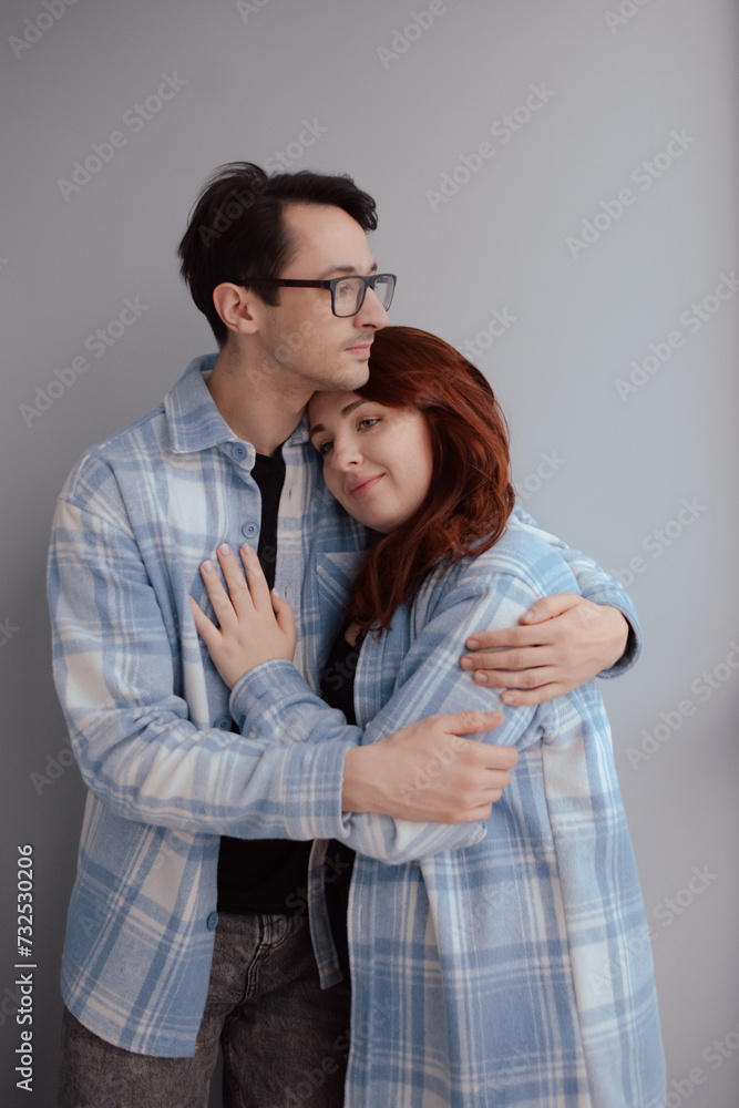sincere hugs of lovers indoors at home on grey wall background. Valentine's Day concept sincere hugs of lovers indoors at home on grey wall background. Valentine's Day concept