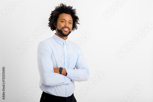 Smiling bearded african-american businessman standing with arms crossed and looking at the camera. Proud and successful small business owner, manager isolated on white photo