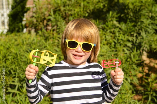 Portrait of a child - Jewish holiday Purim. Boy holding grager, noise maker. The child laughs and rejoices at the merry carnival