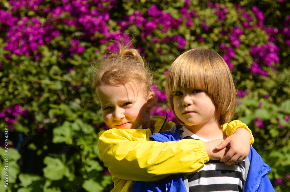 Boy and girl in bright jackets. Brother and sister, first love, kindergarten. Children's hugs