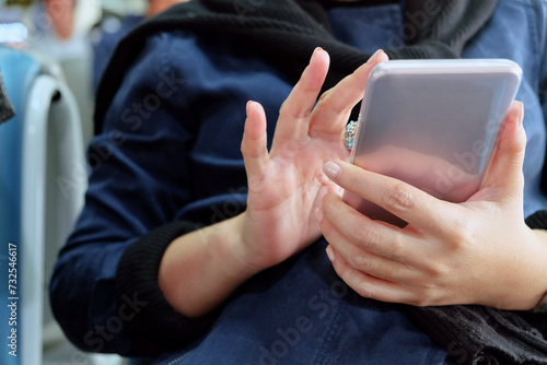 Close-up of a woman's hands holding and using a smartphone