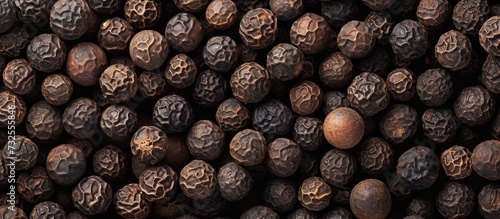 A close-up of black pepper  a natural food ingredient and superfood  resembling a pattern  with a metallic touch.