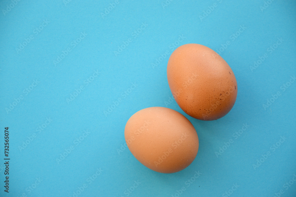 Uncooked egg on pastel blue background. Minimal food concept with copy space