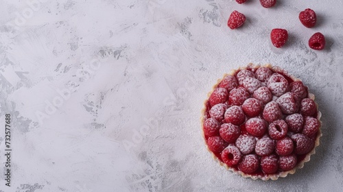 A close - up shot of Raspberry Rosewater Tart, light gray textured plaster background, top view