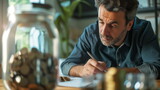 Man sitting at table in front of jar of coins money. Last money from piggy bank, financial crisis, calculation of family expenses. Difficult period of life