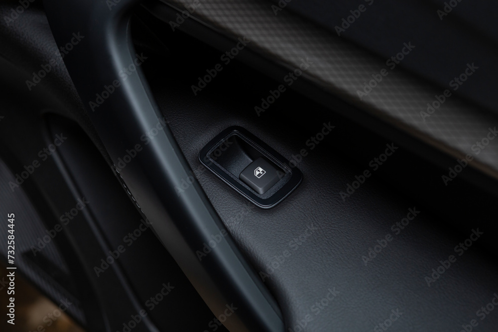 The button of the electric window of the car.An internal accessory of the car.