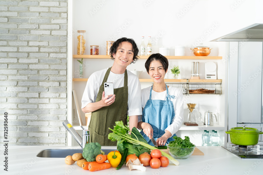 キッチンに立つ笑顔の若いカップル