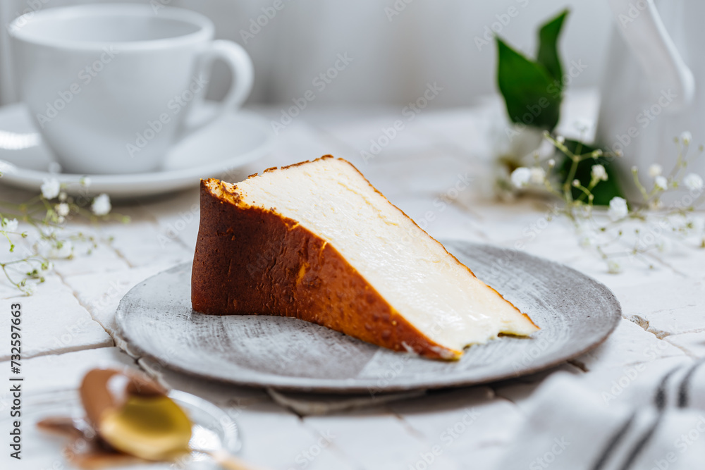 Fototapeta premium Popular Spanish dessert called San Sebastian cheesecake. It also known as burnt cheesecake. One piece of this dessert on white background.
