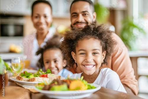 Smiling  multicultural family enjoys a home-cooked meal together  reflecting the rich tapestry of shared traditions and the joyous bond of kinship  diversity  and the love that binds them
