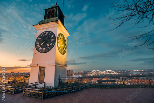 Photos sun sets over Novi Sad, the iconic clock tower of Petrovaradin Fortress stands tall, offering a picturesque view of Serbian history and culture