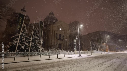 Winter in Bucharest. 4K video during a night snowfall on the streets of the city. CEC Palace (Palatul CEC in Romanian language) landmark building during the night. photo
