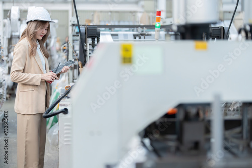Wallpaper Mural Asian female engineer uses her hands to press buttons on the control panel of a plastic and steel production machine in a large industrial factory. Wear a hard hat, have a laptop, radio, suit. Torontodigital.ca