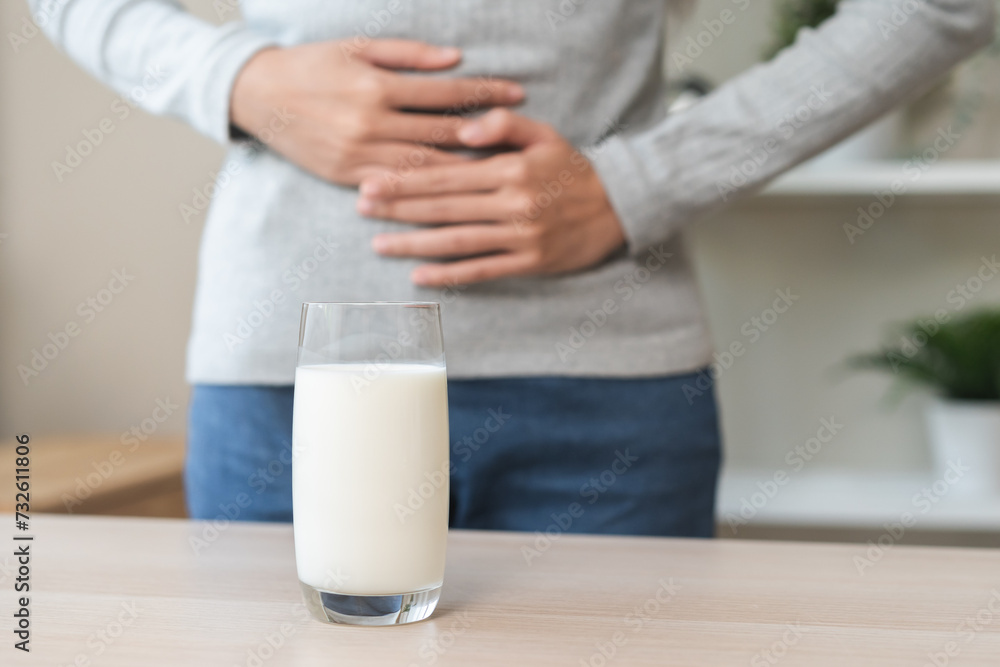 Pain, suffering asian young woman having a stomachache, abdominal pain or digestive, hand in holding belly after drink glass of milk. Lactose intolerance, allergy from dairy food, health care problem. Pain, suffering asian young woman having a stomachache, abdominal pain or digestive, hand in holding belly after drink glass of milk. Lactose intolerance, allergy from dairy food, health care problem.