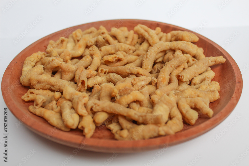 Crispy fried chicken intestines, on a wooden plate, isolated on white background Crispy fried chicken intestines, on a wooden plate, isolated on white background
