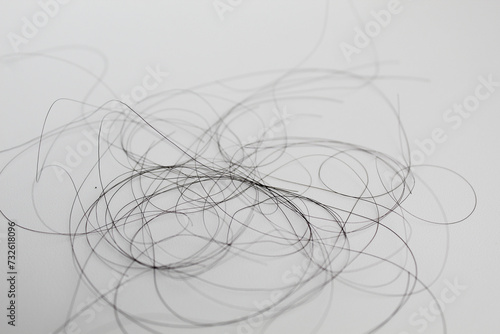 Strands of black hair, isolated on white background. Hair loss or hair falling out or hair breakage