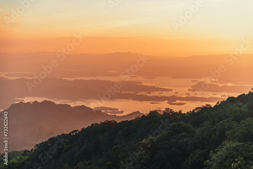 Capture the essence of adventure and tranquility in a striking landscape photo showcasing a camping setup amidst the majestic mountain ranges of Khao San Nok Wua and Pom Pee , Thailand. 