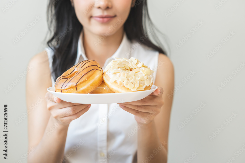 Close up donut plate with happy smile asian young woman, girl temptation food, enjoy eating sugar glazed doughnut and delicious dessert sweet, snack tasty. Eat fast food, junk food meal getting fat. Close up donut plate with happy smile asian young woman, girl temptation food, enjoy eating sugar glazed doughnut and delicious dessert sweet, snack tasty. Eat fast food, junk food meal getting fat.