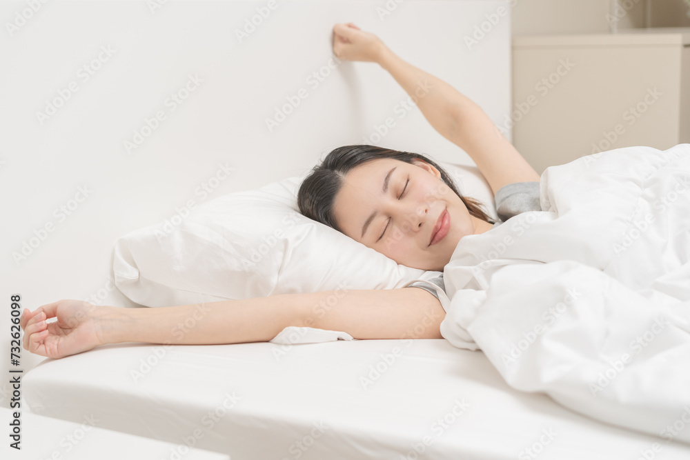 Wake up, beautiful stretching asian young woman waking up after sleep comfortable, rest and relax, closed eyes while with covered blanket, girl stretch in her bedroom,in cozy white bed in the morning. Wake up, beautiful stretching asian young woman waking up after sleep comfortable, rest and relax, closed eyes while with covered blanket, girl stretch in her bedroom,in cozy white bed in the morning.