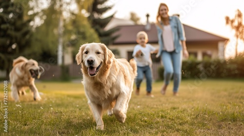 a dog running in the grass with a woman and a child