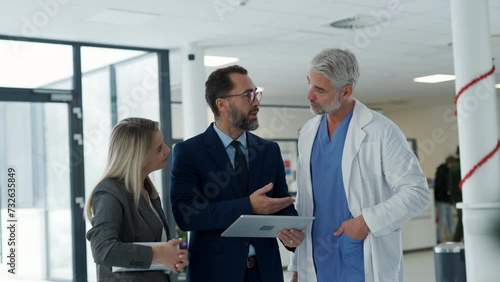 Pharmaceutical sales representatives meeting doctor in medical building. Hospital director and manager talking with head physician in modern clinic, hospital.