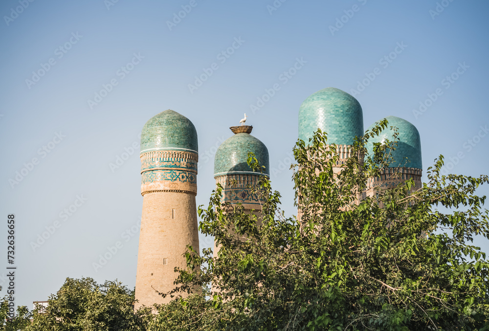 Exterior of Chor Minor Madrasah in the ancient city of Bukhara in Uzbekistan, oriental architecture at sunset in the evening