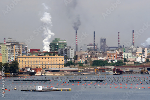 Acciaierie d'Italia steel industry (formerly Ilva, ArcelorMittal and Italsider). Pollution from chimneys on the Tamburi neighborhood of Taranto, Puglia, Italy