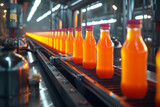 Transparent bottles with orange or tangerine juice on a production line or conveyor belt at a juice factory
