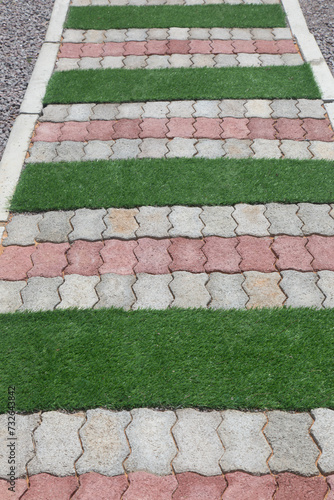 garden path made from grey bricks and green grass © poco_bw