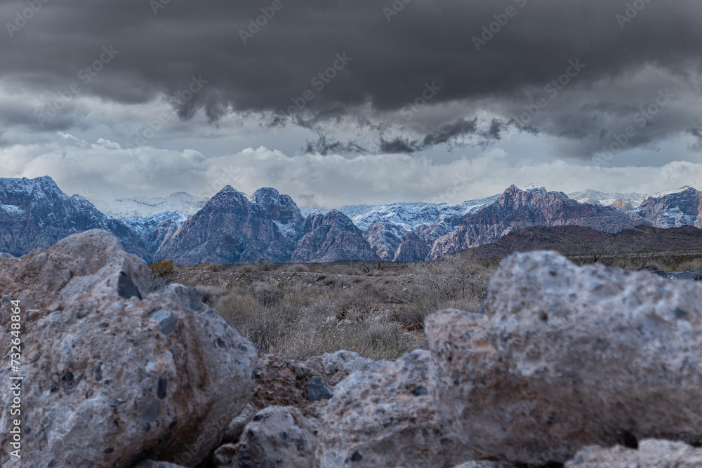 snow capped mountains with storm clouds