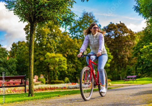 Mid-adult woman riding bicycle in city park
