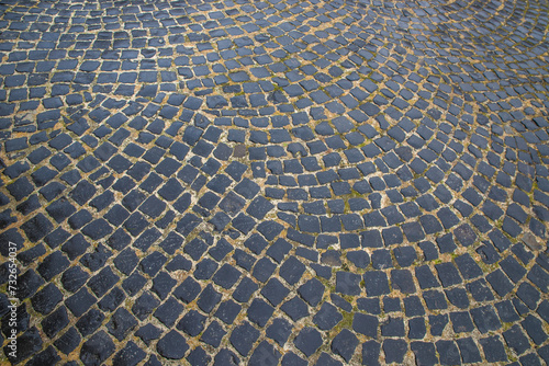 The road is paved with basalt cobblestones.