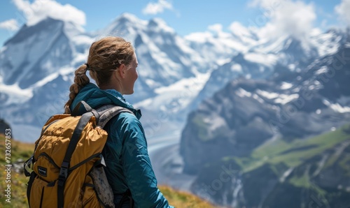 Swiss Alpine Adventure: A Happy Tourist Woman, Backpack-Clad, Revels in the Daytime Splendor of Jungfraujoch, Marveling at the Panoramic Views and Snow-Capped Peaks in the Swiss Alps.      © Mr. Bolota