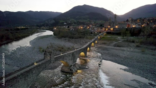 Aerial shot over Gobbo bridge over Trebbia river during sunset, Bobbio, Emilia Romagna, Italy. 