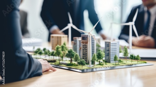 Close-up design of new houses with wind turbines to generate clean electricity. The men of the company solve problems, share their experience in the office.