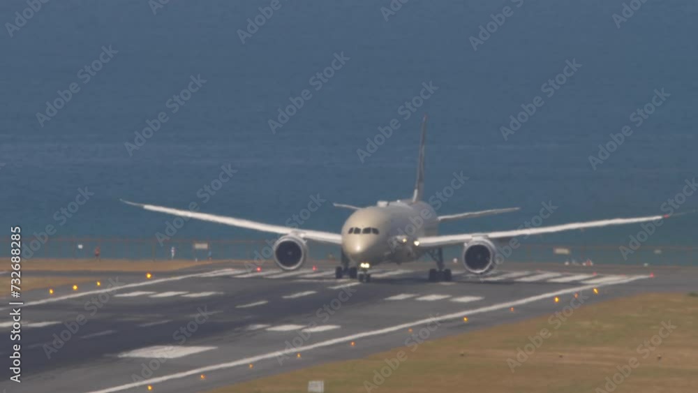 Wide body airliner departure at Phuket Airport. Airplane on the runway, sea background Wide body airliner departure at Phuket Airport. Airplane on the runway, sea background