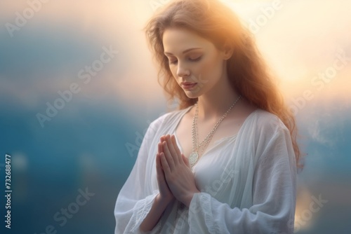 woman in white dress praying in front of the sunrise