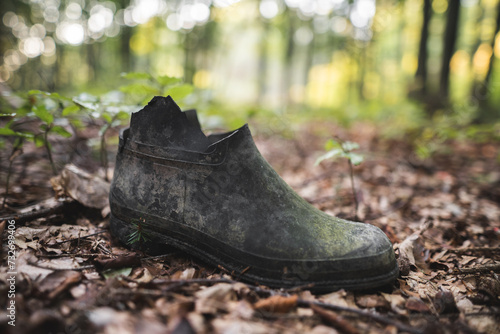 old rubber torn boot left in the forest