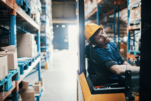 Young man sleeping on the job in a warehouse photo