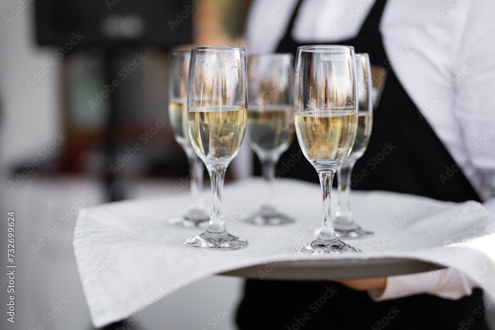 the waiter holds champagne glasses on a tray the waiter holds champagne glasses on a tray