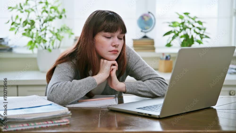 Nervous stressed young female student looking at computer screen Nervous stressed young female student looking at computer screen
