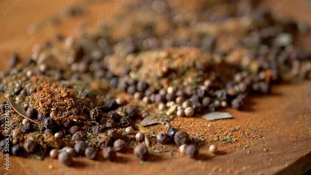 Scattered Various Multicolored Indian Dry Spices on a Rotating Wooden Background. Composition of bright aromatic dry seasonings. Allspice peppercorns, dried herbs, dill, paprika, turmeric, oregano. Scattered Various Multicolored Indian Dry Spices on a Rotating Wooden Background. Composition of bright aromatic dry seasonings. Allspice peppercorns, dried herbs, dill, paprika, turmeric, oregano.