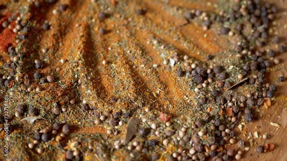 Scattered Various Multicolored Indian Dry Spices on a Rotating Wooden Background. Composition of bright aromatic dry seasonings. Allspice peppercorns, dried herbs, dill, paprika, turmeric, oregano. Scattered Various Multicolored Indian Dry Spices on a Rotating Wooden Background. Composition of bright aromatic dry seasonings. Allspice peppercorns, dried herbs, dill, paprika, turmeric, oregano.