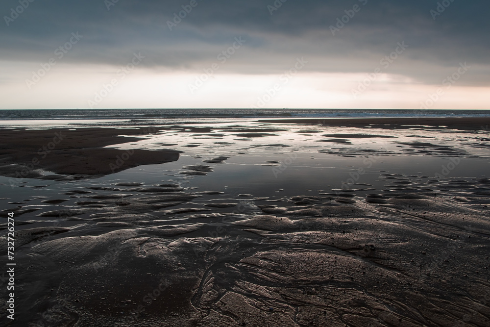 Sunset on the beach at low tide with low tide in the foreground