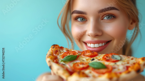 smiling happy young woman eating a slice of pizza with pleasure on a colored background  space for text  food  delivery  delicious meal  portrait  Italian cuisine