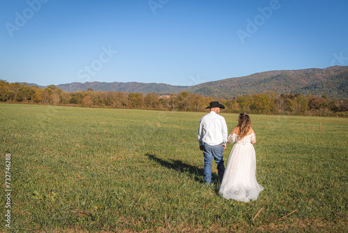 Country couple field stroll to mountains