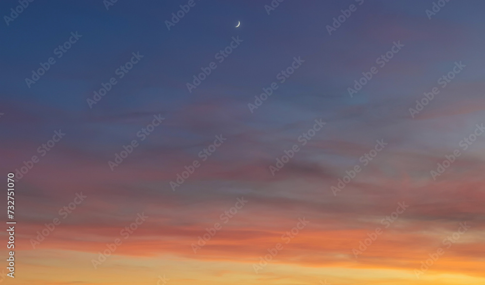 La Luna al tramonto nel cielo blu e arancione  - obrazy, fototapety, plakaty 
