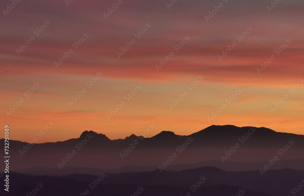 Il cielo rosso di nuvole sopra le montagne al tramonto
