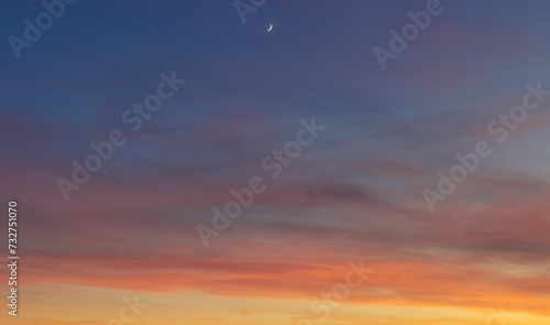 La Luna al tramonto nel cielo blu e arancione  photo